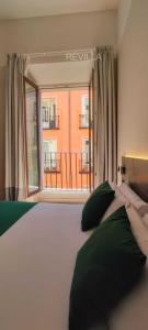a bedroom with a large bed and a window at Hostal Anton Martin in Madrid
