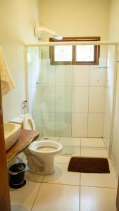 a bathroom with a shower and a toilet and a sink at Vila Clara do Capão in Vale do Capao