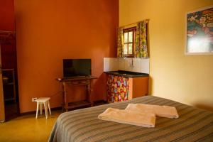 a bedroom with a bed with a towel on it at Vila Clara do Capão in Vale do Capao