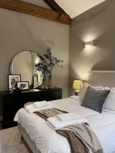 a bedroom with a white bed with a large mirror at Cosy 2 Bedroom Apartment in Todmorden