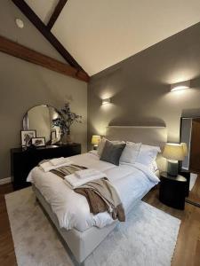 a bedroom with a large white bed and a mirror at Cosy 2 Bedroom Apartment in Todmorden