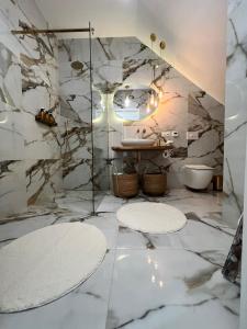 a bathroom with marble walls and a sink and mirrors at Silesia Apartments Ustron H125 in Ustroń