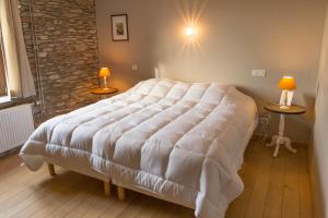 duże białe łóżko w pokoju z dwoma stołami w obiekcie Gîte Coeur de Beurre w mieście Louette-Saint-Denis