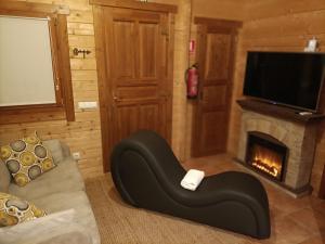 sala de estar con sofá y chimenea en La Dehesilla de Toledo Escapada Romántica Jacuzzi Sillón Tántrico en Cobisa