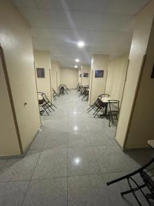 um corredor com cadeiras e mesas num edifício em Makkah Hotel em Qinā