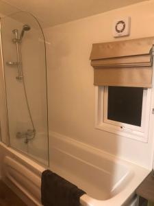 een douche in een badkamer met een glazen douchecabine bij Ravenwood Lodge in Dollar