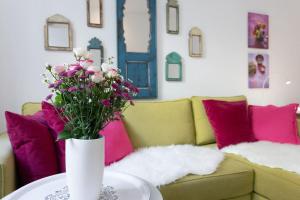 a vase of flowers on a table in front of a couch at Danube Art Apartments in Vienna