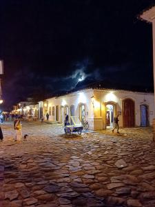 a group of people walking around a street at night at Hospedagem da Val in Paraty