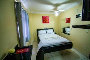 a small bedroom with a bed and a mirror at Hotel Piramide - Iguatemi in Salvador