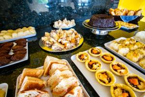 a table topped with different types of pastries and desserts at Hotel Piramide - Iguatemi in Salvador