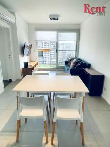 sala de estar con mesa y 2 sillas blancas en Rent - My soho en Buenos Aires