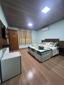Pokój z dwoma łóżkami i telewizorem w obiekcie Pousada Catraca w mieście Pirenópolis