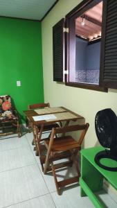 una stanza con tavolo, sedie e parete verde di Chalés da Jack ad Angra dos Reis