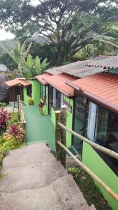 una casa verde con una scala che la porta di Chalés da Jack ad Angra dos Reis