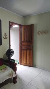 a room with a wooden door and a bed at Chalés da Jack in Angra dos Reis