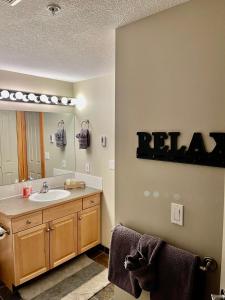 een badkamer met een wastafel en een spiegel bij Canmore Crossing in Canmore