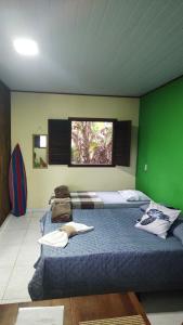 Duas camas num quarto com uma parede verde em Chalés da Jack em Angra dos Reis