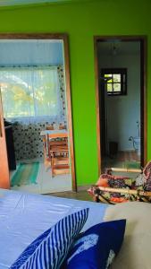 um quarto com uma parede verde com uma cama e uma mesa em Chalés da Jack em Angra dos Reis