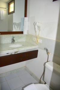 y baño con lavabo, aseo y espejo. en Na praia - Araça 407 Luxo - Lateral vista mar, en Natal