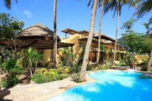 a resort with a swimming pool and palm trees at Vacation Village Phra Nang Lanta - SHA Extra Plus in Ko Lanta