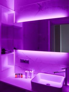 a bathroom with a sink and a purple light at King David Residance in Tbilisi City
