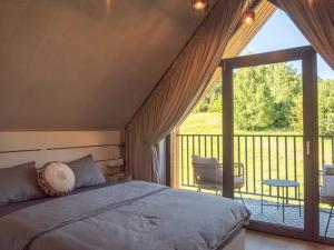 1 dormitorio con cama y ventana grande en Między Brzozami, en Szczytna