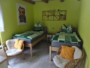 um quarto verde com duas camas e uma cadeira em Haus Lisa em Cottbus
