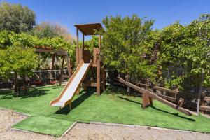 einen Spielplatz mit Rutsche im Garten in der Unterkunft Horizon Line Villas in Kiotari