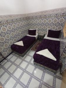 dwa łóżka w pokoju ze ścianą w obiekcie Sindi Sud w Marakeszu