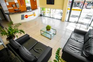 a lobby with a black leather couch and a table at Hotel Piramide Pituba - Av Paulo VI in Salvador