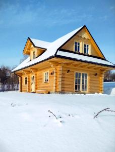 a log cabin in the snow with snow at Dom z bala in Lipowa