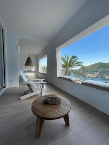 a living room with a table and a large window at Cap Sa Sal suites -Apartament Begur - Costa Brava in Begur