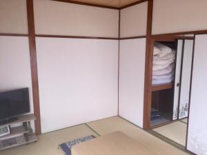um quarto com paredes brancas e uma televisão em D-pdal Inn - Vacation STAY 38493v em Tóquio