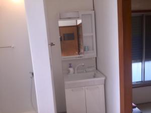 uma casa de banho com um lavatório e um espelho em D-pdal Inn - Vacation STAY 38493v em Tóquio