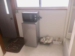 a small refrigerator with a microwave on top of it at D-pdal Inn - Vacation STAY 39054v in Tokyo