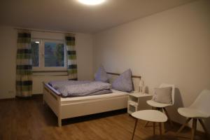um quarto com uma cama, 2 cadeiras e uma janela em Gasthaus Reinhardt em Alfeld