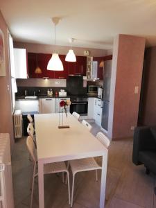 a kitchen and dining room with a white table and chairs at Charmant T3 Gap Sud in Gap