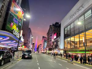 a city street at night with people walking down the street at Buenos Aires desde las alturas in Buenos Aires