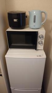 a microwave and a slow cooker on top of a refrigerator at City Pal "kyu Takane Heights" 103 - Vacation STAY 14021 in Tokyo