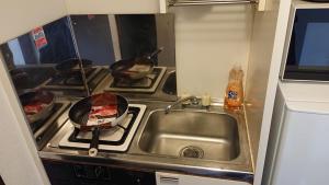 a kitchen with a sink and a stove with pans at City Pal "kyu Takane Heights" 103 - Vacation STAY 14021 in Tokyo