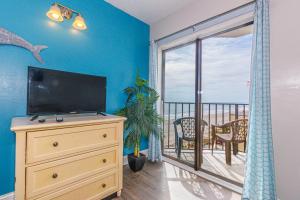 een woonkamer met een televisie en een balkon bij The Palace 505 in Myrtle Beach