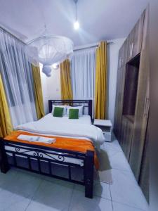 a bedroom with a large bed and a chandelier at Lux Suites Milimani Furnished Apartments in Kisumu