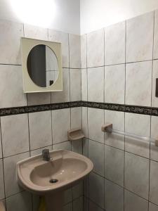 a white bathroom with a sink and a mirror at Céntrico apartamento in La Paz