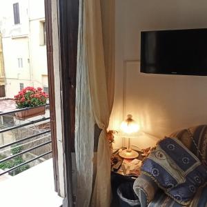 Habitación con sofá y TV en la pared. en B&B "Le Quattro Stagioni", en Agrigento