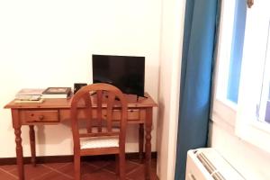 a wooden desk with a chair and a television at La Piccarda nel cuore di Firenze in Florence