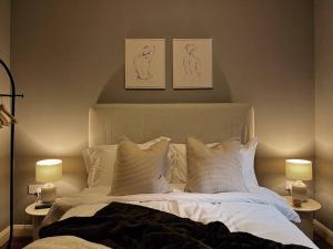 a bedroom with a bed with pillows and two lamps at Modern Ground Floor Apartment in Todmorden