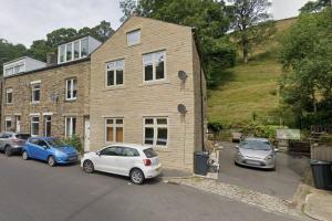 um grupo de carros estacionados em frente a um edifício em Modern Ground Floor Apartment em Todmorden