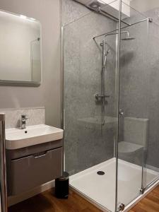 a bathroom with a shower and a sink at Modern Ground Floor Apartment in Todmorden