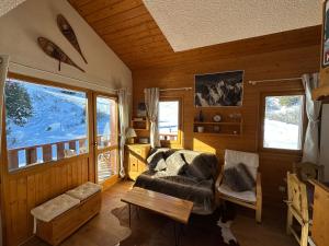 a living room with a couch and a table at Duplex - Plein sud - Pied des pistes - 50m2 - Mottaret in Les Allues