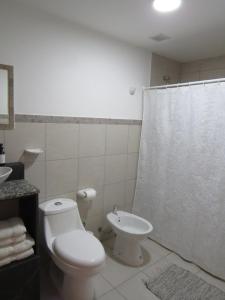 Baño blanco con aseo y lavamanos en Casa Nera en Esquel